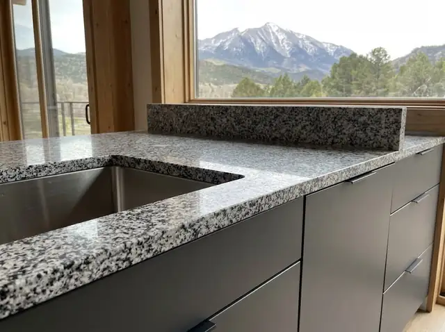 Speckled granite countertop with an undermount sink on graphite cabinets