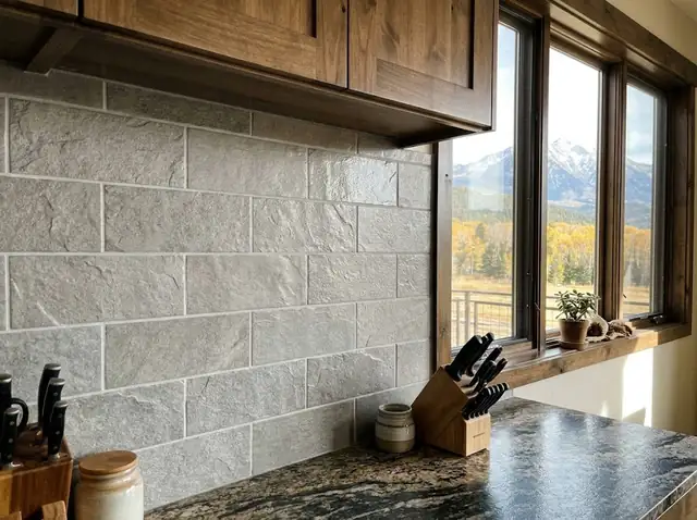 Soft grey stone-look tile backsplash above a granite countertop